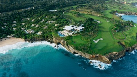 Golf hotel on the rocky coast Caribbean sea. Golf course and villas on the beach. Dominican Republic beach background.