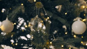 4k footage. movement of Christmas tree with decoration ball hanging on a tree in a lovely home