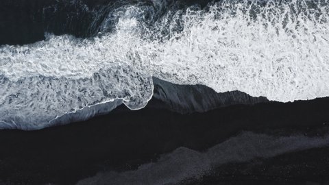 Overhead Slow Motion Drone Shot Of White Surf Patterns Washing Over Black Sand Beach, Iceland