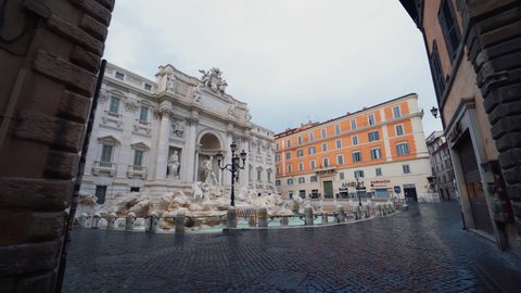 Rome , Italy - 04 20 2020: Gimbal shot around the Trevi Fountain, empty due to COVID-19, overcast day, in Rome, Italy - slow motion