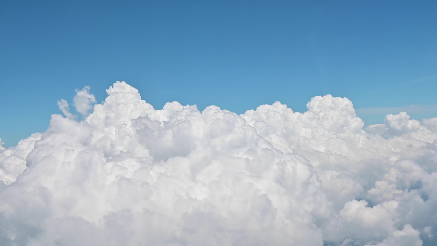 4K Above clouds from airplane window with blue sky Royalty-Free Stock Footage #1063413346