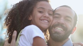 Daughter hugging father outside, mix race child and parent smiling at camera - Powered by Shutterstock - Get 15% off with code: PIKWIZARD15