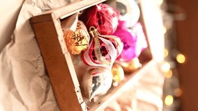 Hand taking beautiful vintage Christmas decoration from wooden box. Vertical video.