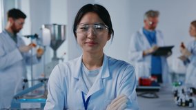 Asian portrait woman scientist with protective glasses look at camera smiling feel happy. Background team work. Microbiology pharmaceutical biochemistry medical technology. Slow motion - Powered by Shutterstock - Get 15% off with code: PIKWIZARD15