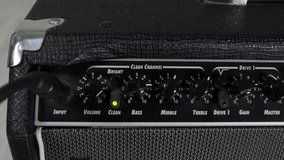 Guitarist adjusting knobs on guitar amplifier. View of the control panel on a guitar amplifier. Tumblers, knobs and buttons. Clean, overdrive and distortion channel. Guitar player school. 4k - Powered by Shutterstock - Get 15% off with code: PIKWIZARD15