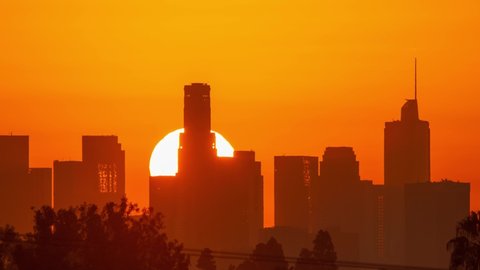 Downtown Los Angeles. Sunrise sun over city buildings silhouettes, zoom out. Timelapse, 4K UHD	
