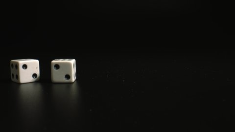 Throwing white dices on a black background. The Numbers Two and Two Appear. High quality.