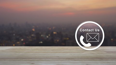 Telephone and mail flat icon button on wooden table over blur of cityscape on warm light sundown, Business contact us concept