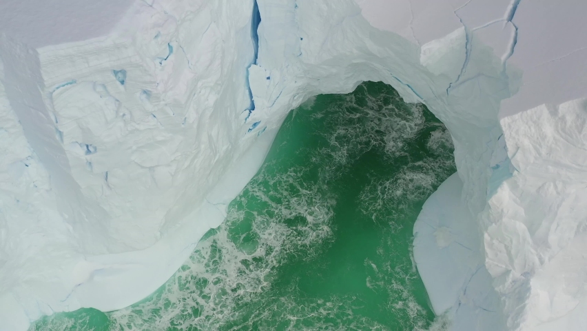 Giant floating Iceberg from melting glacier in Antarctica. 4K aerial drone view shooting. Nature landscape famous for being heavily affected by global warming. Global Warming and Climate Change.