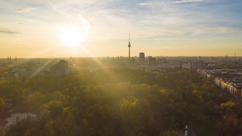 Scenic Hyper Lapse fast moving Time Lapse above Cityscape with Nature and Skyline, Berlin Germany TV Tower in golden hour sunset light, Aerial hyperlapse Establishing Shot