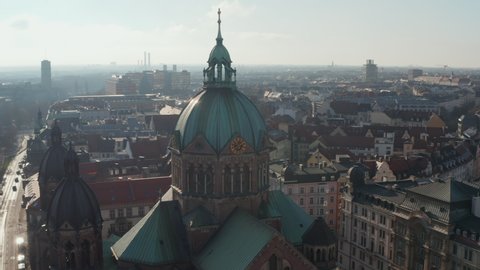 Close Up Aerial View of Cathedral church top with Christian cross and clock on tower, Beautiful Old Architecture in Munich, Germany, Drone Slide circle around building