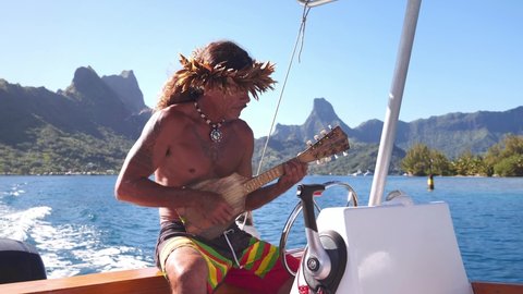 Happy traditional Tahitian man performing, playing ukulele music instrument on tourist tour in Bora Bora, Tahiti. French Polynesia. Exotic travel vacation getaway, romantic honeymoon destination.