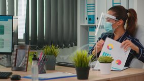 Disabled businessman sitting in wheelchair wearing face protection in prevention for coronavirus cleaning hands before checking financial data in business office. Freelancer respecting social distance - Powered by Shutterstock - Get 15% off with code: PIKWIZARD15