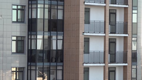 Panoramic video of corner a residential apartment building with balconies and glazing. with cladding tiles and roof ladder