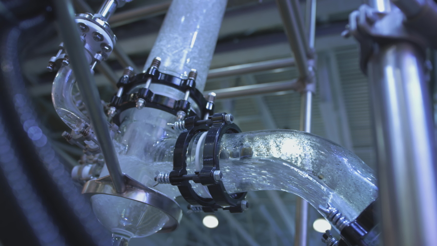 Water flows in a transparent pipe. Transparent pipe to show water flows inside the water supply system. Testing of pumps for oil flow Royalty-Free Stock Footage #1063467322