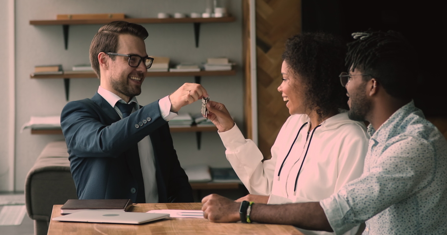 African couple finish successful negotiations with real estate agent sign contract getting keys from new first bought house. Agent shake hands with client clap hands congratulate homeowners concept | Shutterstock HD Video #1063468093
