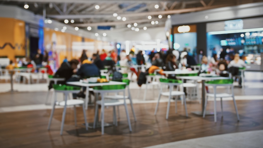 Shot of blurred food court in urban shopping mall, weekend entertainment and family time concept