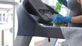 Female worker wearing face mask and disinfecting trainers in a gym during COVID-19 epidemic - Powered by Shutterstock - Get 15% off with code: PIKWIZARD15