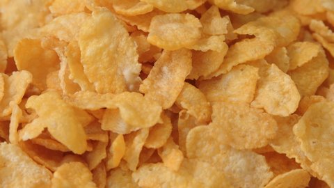 Golden dry cornflakes super close up slowly rotating stock footage