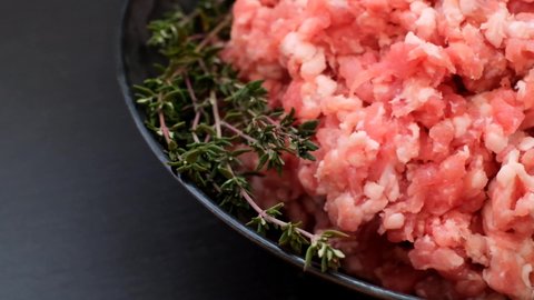 minced pork. fresh raw minced meat close-up in black cup on black slate background