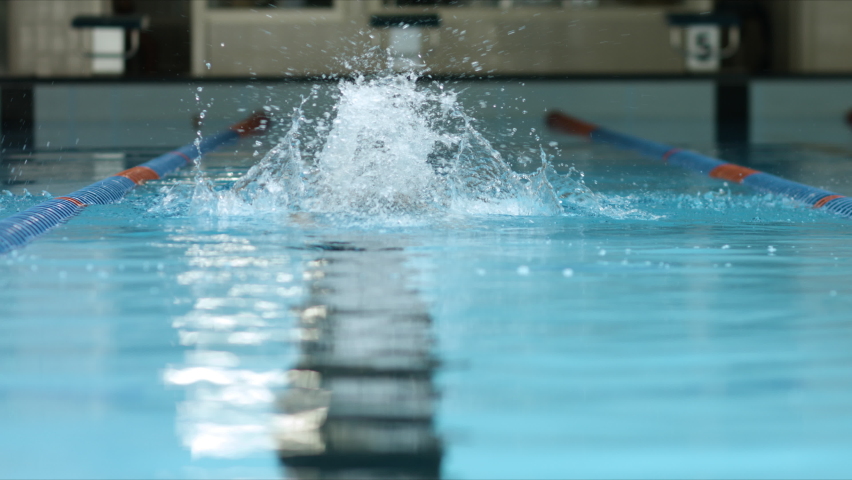 Young female athlete swimmer performing butterfly technique in slow motion video. She takes deep breath before diving under water. Sport and endurance theme. Top shot. Royalty-Free Stock Footage #1063476586