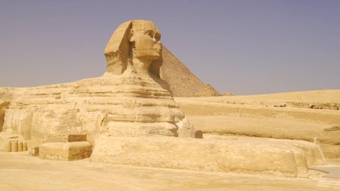 Panning shot of the beautiful Great Sphinx of Giza next to the pyramids of Ginza. Cairo, Egypt
