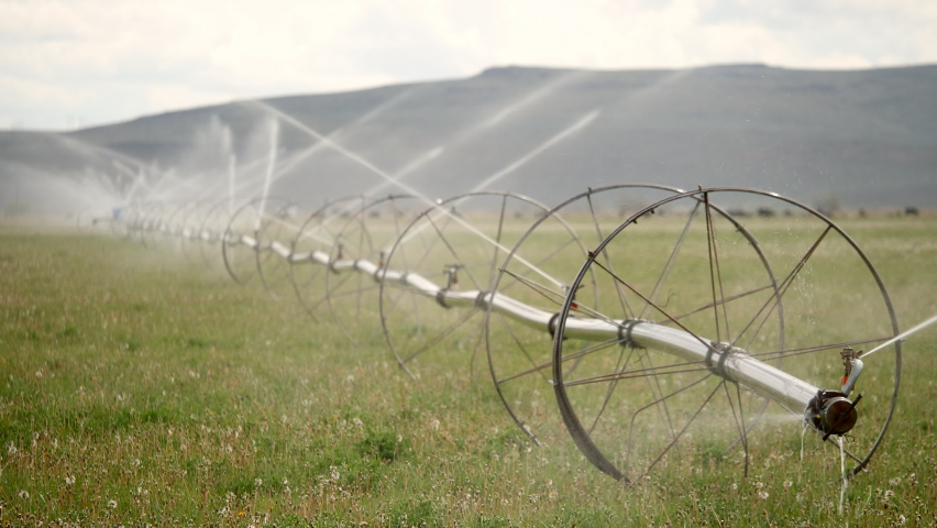 Large sprinklers irrigate farmland on a partly-sunny day near Baker City, Oregon shot in UHD, 3840X2160.
 | Shutterstock HD Video #1063492885