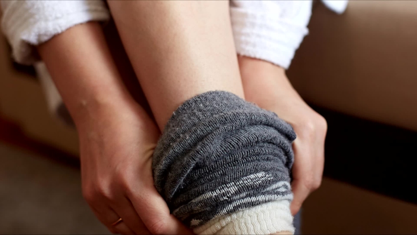 a woman puts on warm gray woolen leggings, women