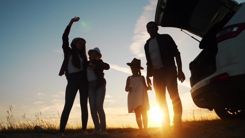 Happy family campsite on a car outdoors silhouette at sunset. parents and kid children look attractions wonders at the sunset nature. day off holiday friendly family dream teamwork concept. lifestyle | Shutterstock HD Video #1063508308