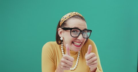 Cheerful vintage style woman giving a thumbs up and smiling at camera