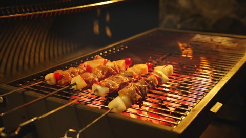 close up street vendor is grilling assorted BBQ meat and vegetable on bamboo skewers with sauce. Street food snack selling at traditional,meat and vegetables are cooked on the grill. BBQ grill.