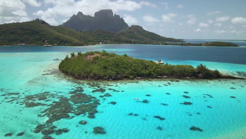 Drone Tahiti, 4k. Aerial view Bora Bora, boat in blue lagoon. French Polynesia. Tropical paradise island. Exotic travel vacation getaway, romantic honeymoon destination. Royalty-Free Stock Footage #1063527355
