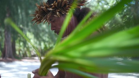 Joyful indigenous traditional Tahitian male making hat from palm leaf on tourist tour in Bora Bora, Tahiti. French Polynesia. Exotic travel vacation getaway, romantic honeymoon destination.