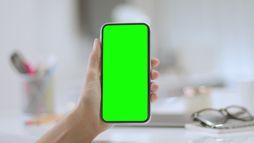 
Lateral dolly of woman using a smartphone. Female hands using a mobile phone with chroma key. Colorful office elements in the background.  Track points with perspective corner pin.    Royalty-Free Stock Footage #1063529137