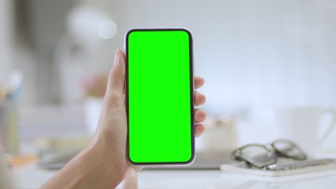 
Lateral dolly of woman using a smartphone. Female hands using a mobile phone with chroma key. Colorful office elements in the background.  Track points with perspective corner pin.   