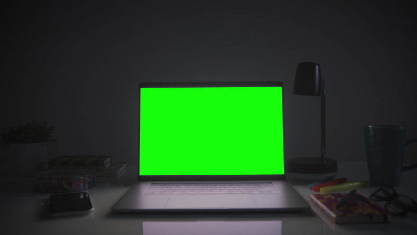 Home office setup with chroma key. Dolly out of laptop with green screen on a white desk. Perfect to put your own images or videos. Track corners with perspective corner pin. Royalty-Free Stock Footage #1063529140