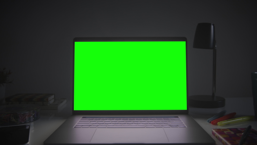 Home office setup with chroma key. Dolly out of laptop with green screen on a white desk. Perfect to put your own images or videos. Track corners with perspective corner pin. Royalty-Free Stock Footage #1063529140
