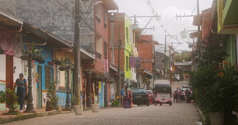 GUATAPE, COLOMBIA - CIRCA 2019: View of a street in the popular touristic resort town Guatape, near Medellin, Antioquia, warm, humid mist in the air