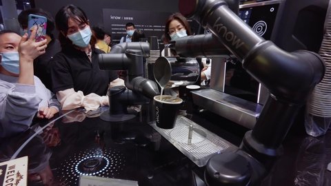Guangzhou , Guangdong , China - 12 04 2020: Coffee making Robot barista making a cup of coffee in front of visitors at kitchen design exhibition in China, during COVID-19 Pandemic.