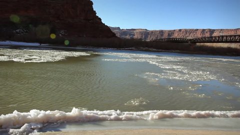 Frozen winter Colorado river and bridge Moab Utah Stock Video