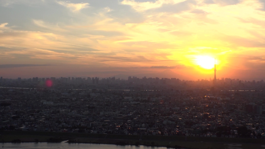 TOKYO, JAPAN : Aerial high angle sunrise CITYSCAPE of TOKYO and MOUNT FUJI. View of rising sun and buildings at downtown area. Japanese city life and nature concept. Time lapse shot night to morning.