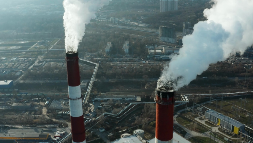 Epic aerial of high smoke stack. Plant pipes pollute atmosphere. Industrial factory pollution, smokestack exhaust gases. Industry zone, thick smoke plumes. Climate change, ecology.  Royalty-Free Stock Footage #1063556212