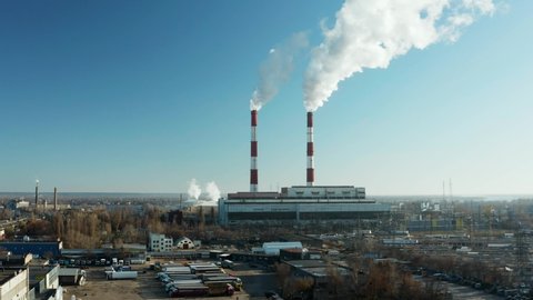 Epic aerial of high smoke stack. Plant pipes pollute atmosphere. Industrial factory pollution, smokestack exhaust gases. Industry zone, thick smoke plumes. Climate change, ecology. 