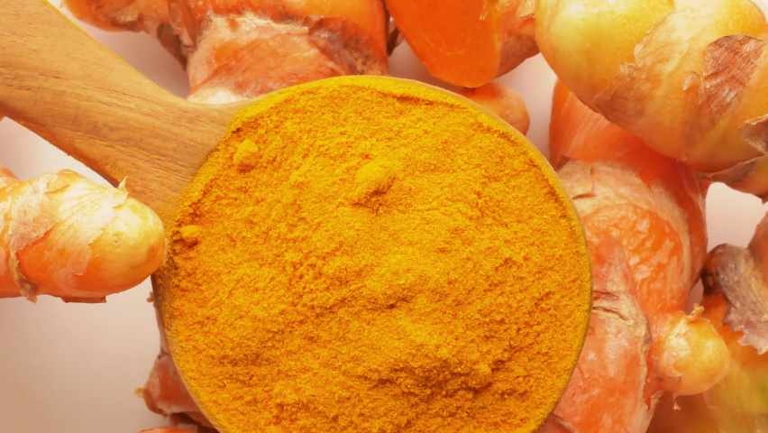 Turmeric and Turmeric powder in a wooden spoon Rotation Royalty-Free Stock Footage #1063556938
