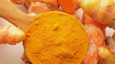 Turmeric and Turmeric powder in a wooden spoon Rotation