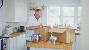 Senior couple downsizing in retirement packing and labelling boxes in kitchen ready for move into new home - shot in slow motion - Powered by Shutterstock - Get 15% off with code: PIKWIZARD15