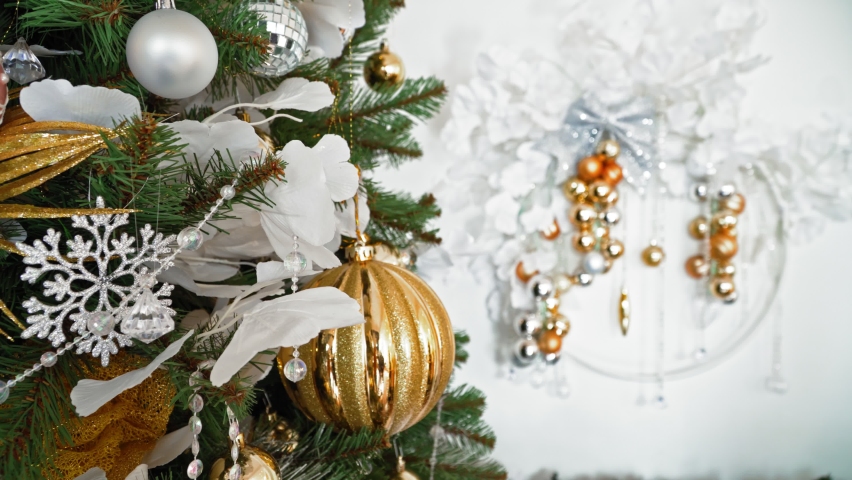  New Year fir tree with decorations and illumination. Christmas tree lights glittering. Many large golden balls on Christmas tree.