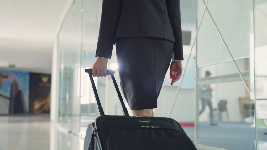 Close up view on hand of Female flight attendant dragging baggage or suitcase, walking to passenger terminal in airport. Cabin crew occupation concept. Royalty-Free Stock Footage #1063563502