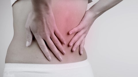 Pain in the back. Backache. Back view of a woman having problems with the spine. Healthcare concept