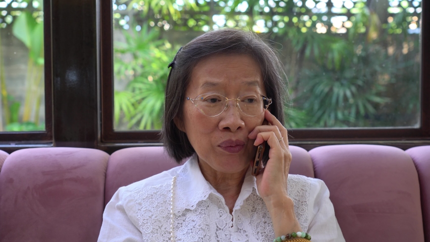 
beautiful asian senior woman using smartphone to talk with family